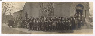 Group of men dressed in winter coats in front of a church