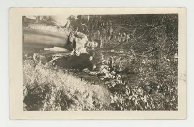 Graduates posing in a forest postcard