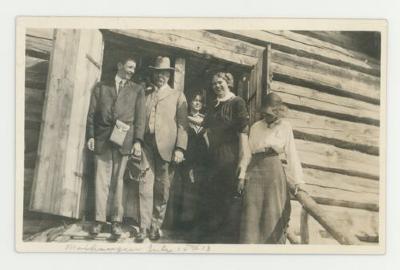 Individuals in front of a wooden structure postcard