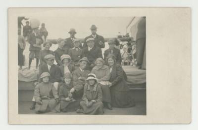 Large group posing for a photograph on a boat postcard