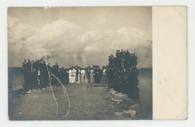 Individuals posing for a photograph over a lake postcard