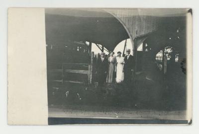 Individuals on a train platform postcard